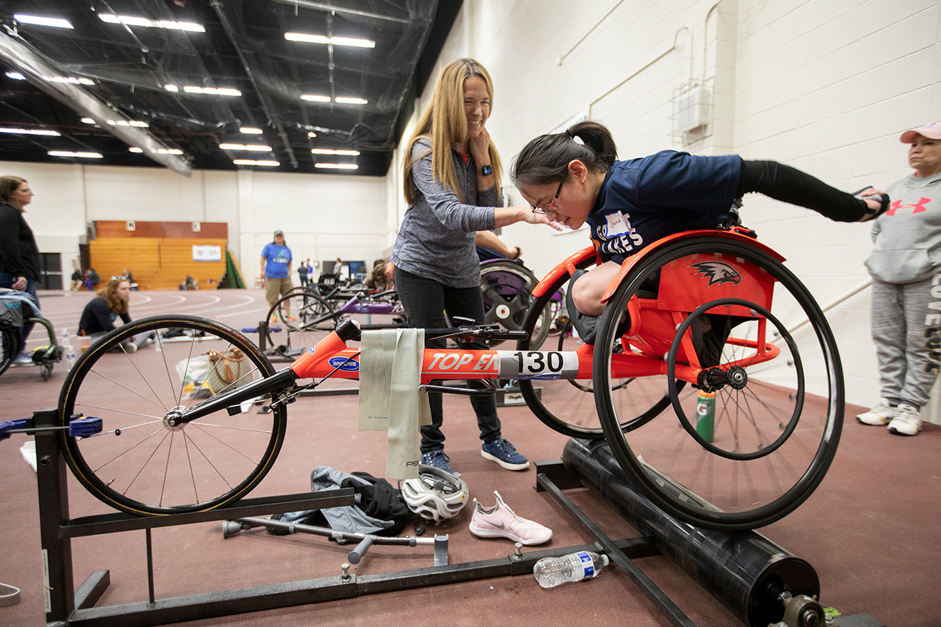 Girl in racing chair working out on roller.
