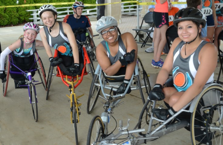 Smiling girls in track chairs